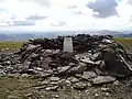 Der Gipfelcairn des Driesh mit einem trigonometrischen Punkt