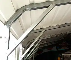 Metallisches Tragwerk eines Schuppens; durch Strebe versteifte Eckverbindung zwischen Ständer und Sparren.