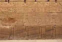 Relief mit vier Personen mit unterschiedlichen Hieroglyphen auf dem Kopf