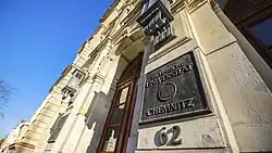 Große Eingangstür mit Plakette, auf der Technische Universität Chemnitz steht.