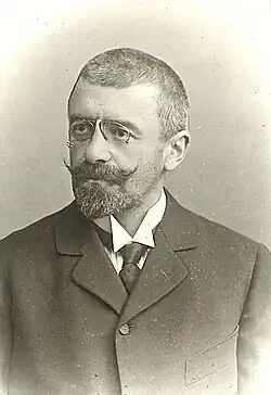 Emil von Ottenthal auf einem alten Porträtfoto mit Brille, weißem Hemd und in dunklem Anzug.