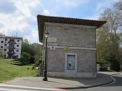 Ehemaliges Empfangsgebäude in Loyola: Links die ehemalige Bahntrasse, im Hintergrund ein Eisenbahntunnel