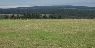 Ergenstein (Mitte) aus Süden vom Kemeler Rücken bei Kemel; mit Windrad nahe Berghausen und Westerwald (Horizont)