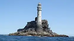 Das Bild zeigt die Insel Fastnet Rock im Südwesten von Irland. Es ist eine kleine, felsige Insel mit einem auffälligen Leuchtturm