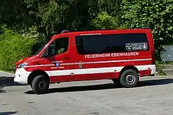 Ein von der Seite fotografierter roter Mercedesbus mit der weißen Aufschrift Feuerwehr Ebenhausen.