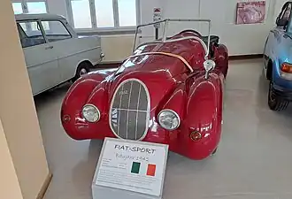 Front (im Hintergrund ein Foto des Fahrzeugs während einer Oldtimer-Rallye)