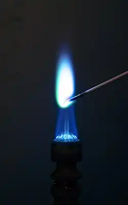 Demonstration der Flammenfärbungen durch Erhitzen von Kupfer(II)-chlorid in der Flamme eines Bunsenbrenners.