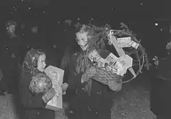 Schwarzweiß-Fotografie von zwei Kindern mit Geschenken auf dem Arm