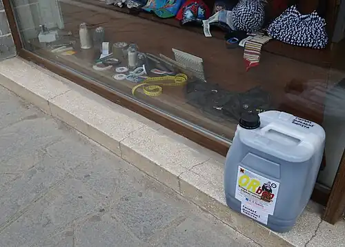 Kanister mit Lederblende vor einem kleinen Pelzutatenladen