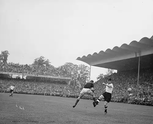 2. Minute: Die deutsche Mannschaft ist zu Beginn des Endspiels auf Angriff eingestellt. Buzánszky kann sich gegen Ottmar Walter durchsetzen. Im Bild von links nach rechts: Fritz Walter (D, hinten), Buzánszky (U), Ottmar Walter (D).