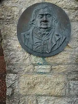 Gedenkstein, Das weisse Kreuz im roten Feld. Für Friedrich Oser (1820–1891) Pfarrer und Dichter, in Biel-Benken, Kanton Basel-Landschaft. Koordinaten 47°30'43.9"N 7°31'16.8"E