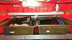 Reihe an Stirnwand mit wasserführenden Armaturen rechts und Einmannduschzelt links