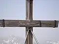Das Gipfelkreuz des Hohen Bretts, im Hintergrund der Hochkalter (2608 m).