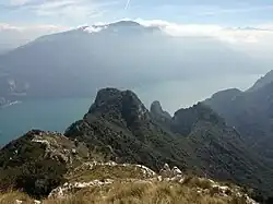 Der Bergrücken der Rocchetta mit der Grotta Dazi, Cima Capi und der Cima Rocca, im Hintergrund der Monte Altissimo di Nago
