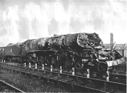 Beschädigte Dampflokomotive mit eingedrückter Rauchkammer im vorderen Kesselbereich sowie fehlenden Dampfzylindern und Treibstangen