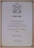 1983, 31. Mai. Urkunde. Die Kärntner Landesregierung verleiht Hans Pawlik, 3. Präsident des Kärntner Landtages a. D., den „Kärntner Landesorden in Silber“.