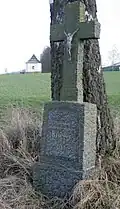 Gedenkkreuz für Massengräber, Kapelle im Hintergrund
