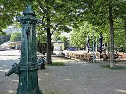 Henriettenplatz, Sitzplätze vor dem Restaurant und historische Wasserpumpe
