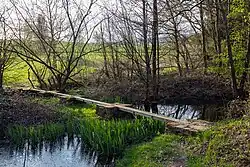 Hannes Forster, Überbrückung, 1988, 0–30 × 110 × 110 × 1700 cm Bruchsteine, Vierkanthölzer, Teiche, Bach. Standort im Tal (Skulpturenpark) zwischen Hasselbach und Werkhausen