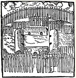 Dorf mit mehreren Häusern um einen Platz, das von Palisaden eingezäunt wird.