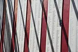 Auf weißen Fahnen stehen im Haus des Gedenkens die Namen der Toten des KZ Neuengamme. Die Wand an denen die Stoffbahnen hängen, ist rot gestrichen