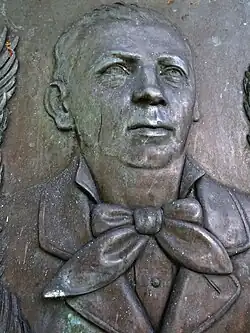 Gedenkstätte bei der reformierten Kirche in Gelterkinden für Heinrich Handschin (1830–1894) Unternehmer. Werk (1895) von Joseph Wilhelm Hollubetz (1848–1910), Bildhauer. Lehrer an der Allgemeinen Gewerbeschule in Basel