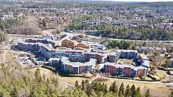 Luftbild einer von Bäumen umgebenen dichteren Bebauung