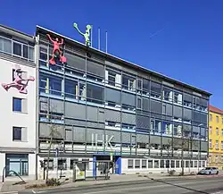 Schiefer Blick auf gläserne Fassade mit Perspektivkorrektur; blauer Himmel; Motiv wird beschienen
