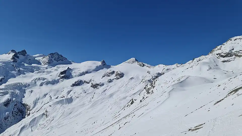 Punta Orientale della Sella, Punta Occidentale della Sella, Cima Sondrio, Piz Glüschaint, La Muongia und Il Chapütschin (v. l. n. r.), aufgenommen von Murtèl Sur (für Annotationen der einzelnen Berge aufs Bild klicken)