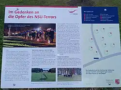Überschrift: „Im Gedenken an die Opfer des NSU-Terrors“. Informationstext mit Gedenkveranstaltung zum 10. Jahrestag der NSU-Selbstenttarnung, dem abgesägten Baum und dem Steinmeier-Besuch, Auf der rechten Seite eine Karte mit der Positionierung der einzelnen Bäume.