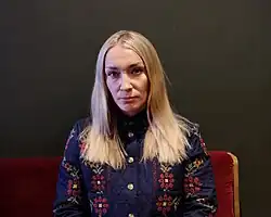 Inna Schewtschenko auf einem Sofa, schaut ernst in die Kamera