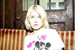 Jasmin Baumgartner sitzt auf gestreiftem Sofa und blickt direkt in die Kamera