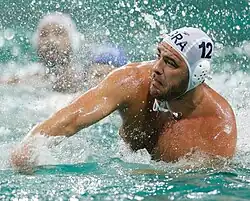 Josip Vrlić ist im Wasser und hat gerade geworfen. Auf der weißen Bademütze steht seine Nummer 12.