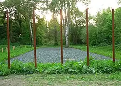 Darstellung der früheren Baracke des Krankenreviers durch Schotter und Metallstelen