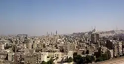 Kairo vom Minarett der Ibn-Tulun-Moschee aus gesehen. In der Bildmitte die Sultan-Hasan-Moschee und die Al-Rifa'i-Moschee, rechts auf dem Hügel der Zitadelle die Muhammad-Ali-Moschee.