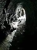 Blick aus dem Inneren zum Eingang. Beachte den nassen Höhlenboden