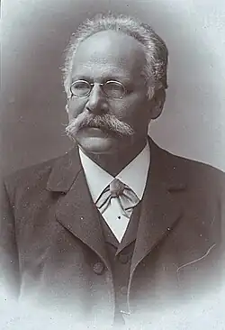 Karl Exner mit Klemmbrille, grauem Schnurrbart und dunklem Anzug