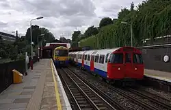 London: Begegnung eines Zuges der London Overground (links) und der Bakerloo Line der Underground (rechts) am Bahnhof Kensal Green