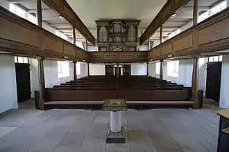 Kirche Oberschmon Blick auf die Orgel, das Kirchengestühl und den Taufstein