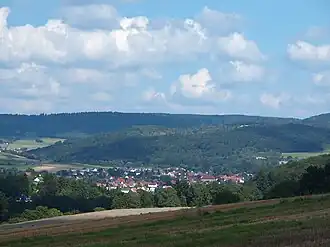 Der Nöll, im Tal unterhalb der Ort Oberaula. Der Bergrücken hinter dem Nöll ist etwa 570 m hoch, u. a. die Teufelskanzel.