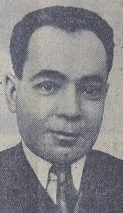 Gesicht eines Mannes in den 50er Jahren von vorn ab Schulterblatt im Jackett, weißem Hemd und dunkler Krawatte und die Kamera schauend.