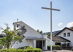 Kirche mit großem frei stehendem Kreuz daneben