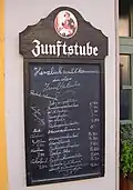 Tafel mit Speisekarte vor einem Gasthaus in Kulmbach