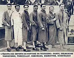 Schwarzweißfoto der Mannschaft von Neptune de Tourcoing aus dem Jahr 1925. Zu sehen sind sieben Herren in Bademänteln, von denen nur zwei barfuß sind.
