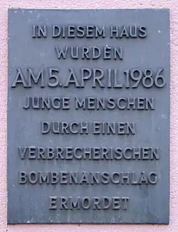 Gedenktafel mit Aufschrift „In diesem Haus wurden am 5. April 1986 junge Menschen durch einen verbrecherischen Bombenanschlag ermordet“