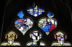 Maßwerk mit der Verkündigung des Herrn, darüber der Kopf des heiligen Claudius, und darunter die Wappen der Stifterfamilie