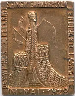 Dieser Anstecker aus dem Jahr 1928 zeigt das Lassalle-Denkmal im Winarsky-Hof in der Brigittenau (Wien), das 1936 abgetragen wurde