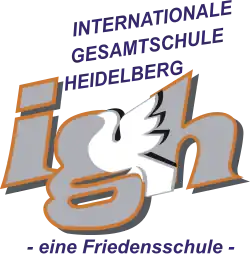 Die Buchstaben I, G und H umrahmen eine weiße Taube. Darüber der Schriftzug Internationale Gesamtschule Heidelberg", darunter steht „eine Friedensschule“.