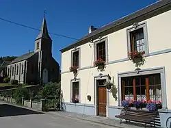 Mit Blumen geschmücktes Dorfshaus neben der Kirche