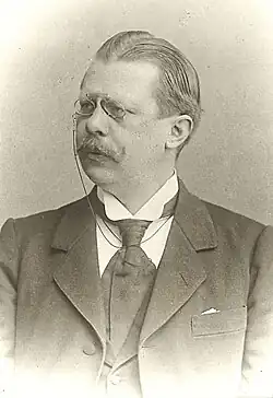 Ludwig von Pastor mit Klemmbrille, Schnurrbart, breiter Krawatte und in dunklem Anzug.